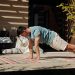 Adult man doing a plank exercise on a colorful yoga mat outdoors, promoting fitness and healthy living.