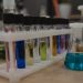 A collection of colorful test tubes and flasks in a chemistry laboratory setting.